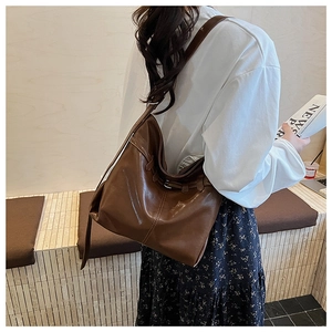 Deep brown leather tote bag detail showing large capacity and vintage buckle design