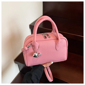Detail of pink lychee grain leather mini bowling bag with a silver whale charm