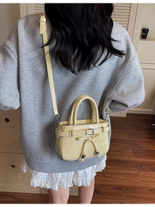 Pale yellow ruffled leather crossbody bucket bag with star pendant and slim shoulder strap