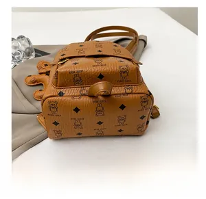 Detail of wear-resistant base on brown faux leather backpack with bear pattern