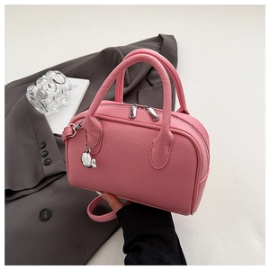 Pink boston handbag with lychee texture leather and silver fish charm on the side