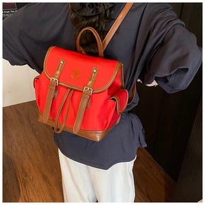 Detail of red vintage backpack with heart tulip embroidery and leather strap buckles