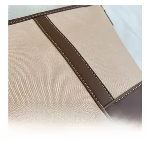 Detailaufnahme einer hochwertigen Eimer-Tasche aus Canvas und Leder mit präzisen weißen Nähten