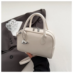 Detail of off-white lychee texture bowling bag with silver hardware and whale charm