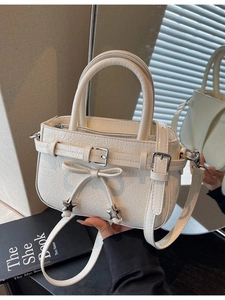 Chic off-white pleated patent leather bucket bag with bow and star charm detail