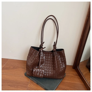 Close-up of dark brown woven leather tote with classic intrecciato weave and mini pouch