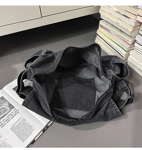 Makroaufnahme der großen schwarzen Denim-Tasche mit Reißverschlussfach und geräumigem Stauraum