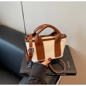 Detail of vintage canvas and brown leather crossbody bag with silver buckles