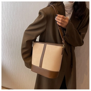 Detail of vintage canvas bucket bag with brown leather trim and contrast stitching