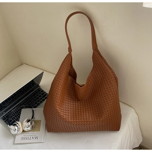 Detail of a large brown woven hobo bag showing intricate cross-weave texture and strap