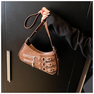 Detail of vintage brown leather bag featuring metal buckles and motorcycle style zippers
