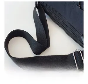 Detail view of the adjustable black nylon shoulder strap with silver metal buckle on a bag
