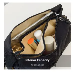Detail view of the black multi-compartment nylon bag showing spacious interior and triple zippers