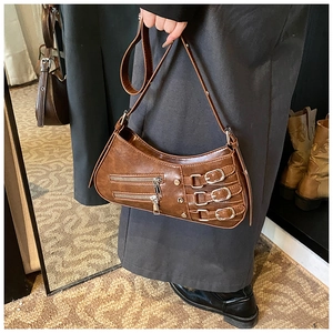 Detail of vintage brown leather bag with silver metal buckles and zipper accents