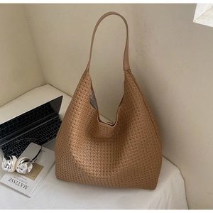 Detailed view of the woven brown leather tote bag with sturdy straps and fabric lining