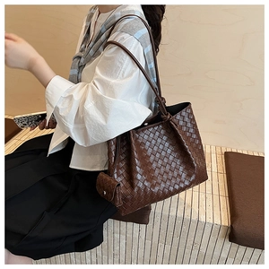 Detailed view of the dark brown wide-weave leather tote bag and matching mini pouch zipper