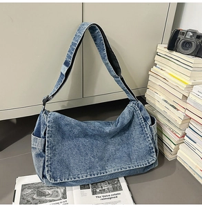 Detailansicht der Jeans-Umhängetasche mit Klappenverschluss und Seitentaschen im Lifestyle-Stil