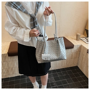 Detail view of woven silver tote bag with matching mini pouch and knotted handle detail