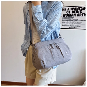 Close-up of gray nylon shoulder bag showing waterproof texture and zipper details