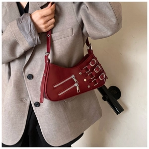 Detail of burgundy ruched hobo bag with dual zippers and silver buckle straps on model
