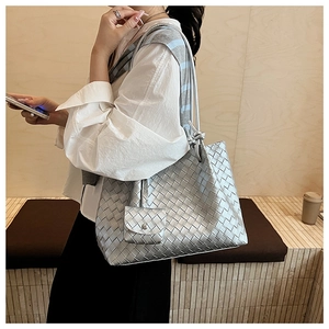 Detail view of silver woven tote bag with matching square coin pouch and texture