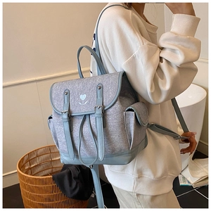 Detail of light blue retro backpack with flower embroidery and leather buckle straps