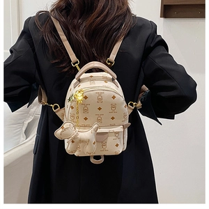 Rear view of a beige mini teddy bear backpack with diamond quilted pattern and bag charm