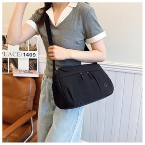 Close-up of black nylon crossbody bag with multi-zipper pockets and large capacity