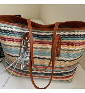 Nahaufnahme der gewebten Strohtasche mit bunten Streifen, Ledergriff und Stern-Anhänger