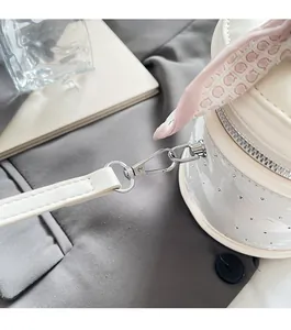 Détail du sac seau blanc brillant avec ferrures argentées et foulard en soie rose
