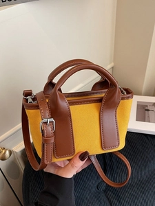 Chic yellow canvas tote bag with brown leather trim and shoulder strap in casual style