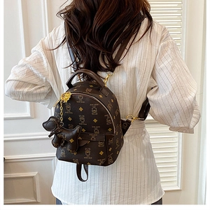 Detailed back view of mini brown teddy bear monogram backpack on model with gold hardware