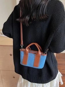 Mini navy canvas and brown leather crossbody bag shown on model for size and style
