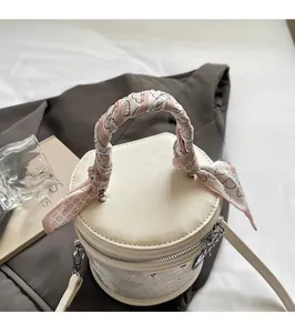 Détail du sac seau crème avec poignée en foulard de soie et fermeture éclair en métal