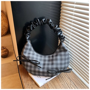 Detail der karierten Hobo-Tasche mit schwarzen Lederschleifen und gerafftem Griff