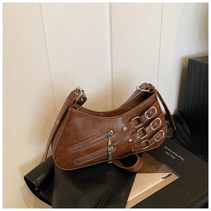 Detailed macro view of vintage brown pleated hobo bag with punk silver buckles and rivets