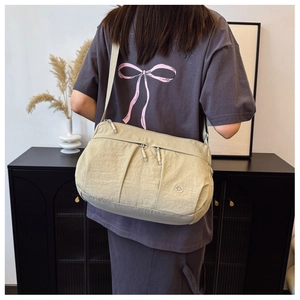 Detail of light khaki crossbody bag with multi-zipper pockets and wrinkled nylon fabric