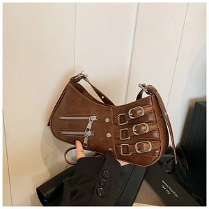 Macro detail of brown pleated leather bag featuring silver buckles and punk zippers