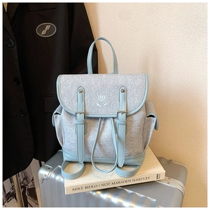 Close-up of light blue PU leather and tweed backpack with white tulip embroidery detail