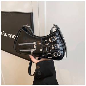 Detail of black punk shoulder bag with silver zippers and metal pin buckles