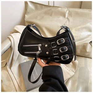 Close-up of black crescent bag with triple silver buckles and dual zippers detail