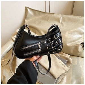Close-up of black punk shoulder bag featuring metal zippers, buckles and rivet details
