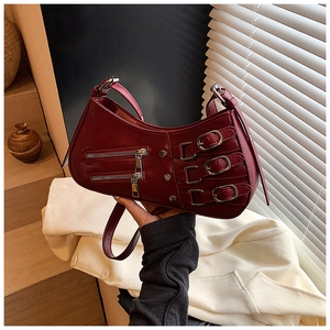 Close-up of wine red crescent bag featuring silver buckles and motorcycle style zippers