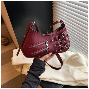 Detail view of burgundy motorcycle bag with double zippers and metal buckle straps