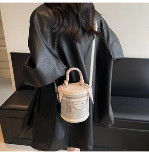Détail du mini sac seau blanc avec texture pailletée, poignée foulard et breloque cadenas