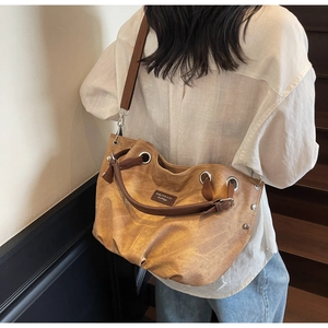 Large mustard yellow canvas tote bag with brown leather straps shown on a wooden staircase