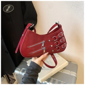 Detail shot of the dark red saddle bag featuring biker style buckles and silver zippers