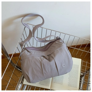Detail of grey-purple nylon crossbody bag with pleated texture and adjustable strap