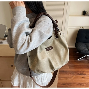 Modern minimalist large tote bag in light grey-green shown on shoulder of female model