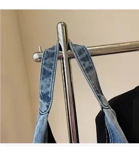 Close-up of durable double-stitched denim handles on a large blue tote bag